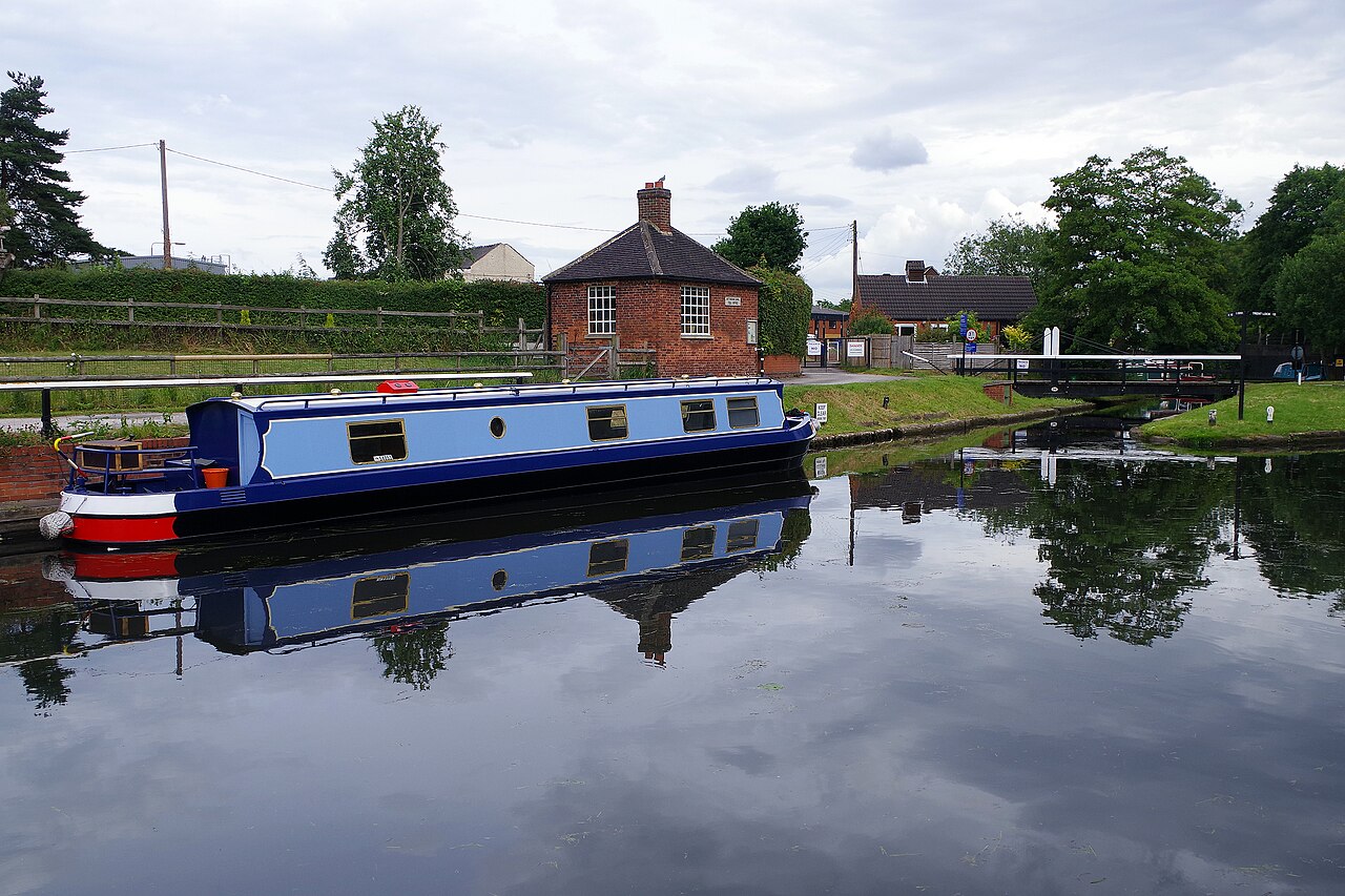 A narrowboat moored at the Great Northern Basin, with the Victorian pump house behind it.
